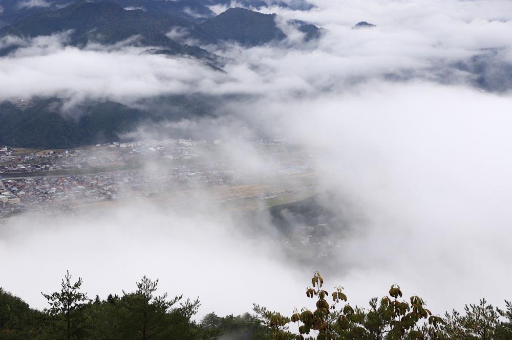 雲海の切れ間から古川盆地を眺める