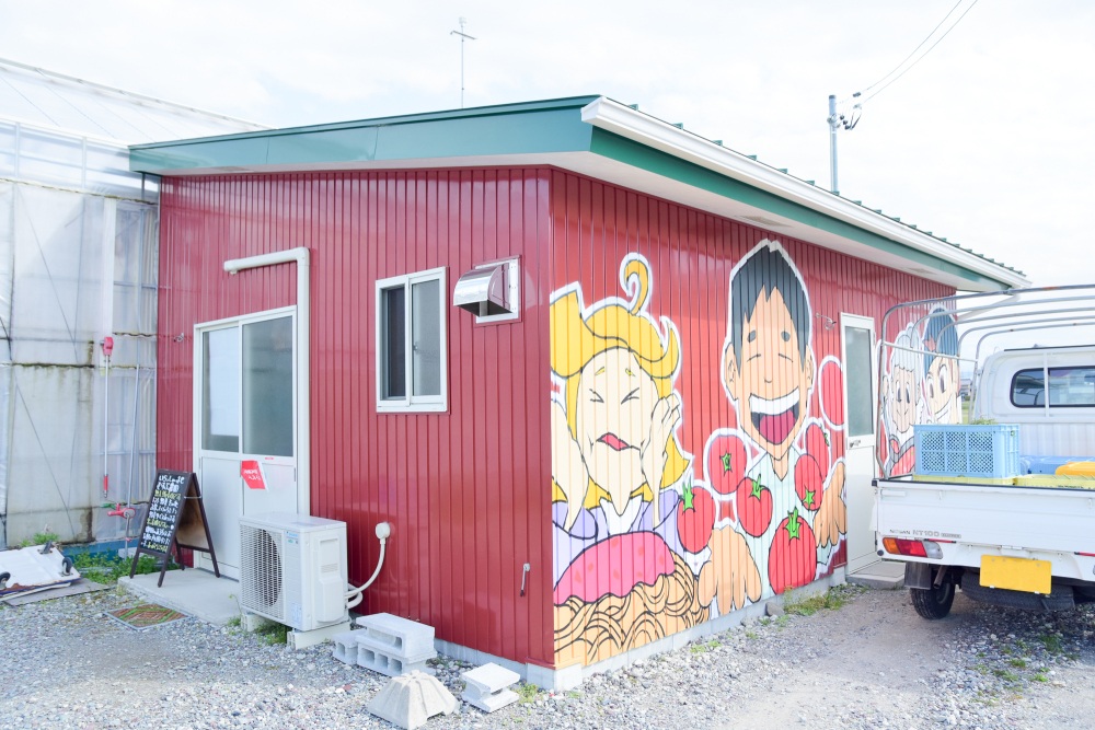 トマトを持った戸田さんのイラストが印象的な直売所外観