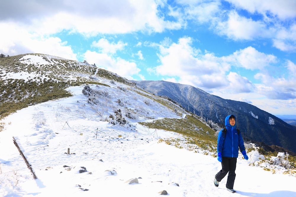 恵那山を背景に、白銀の稜線を歩く