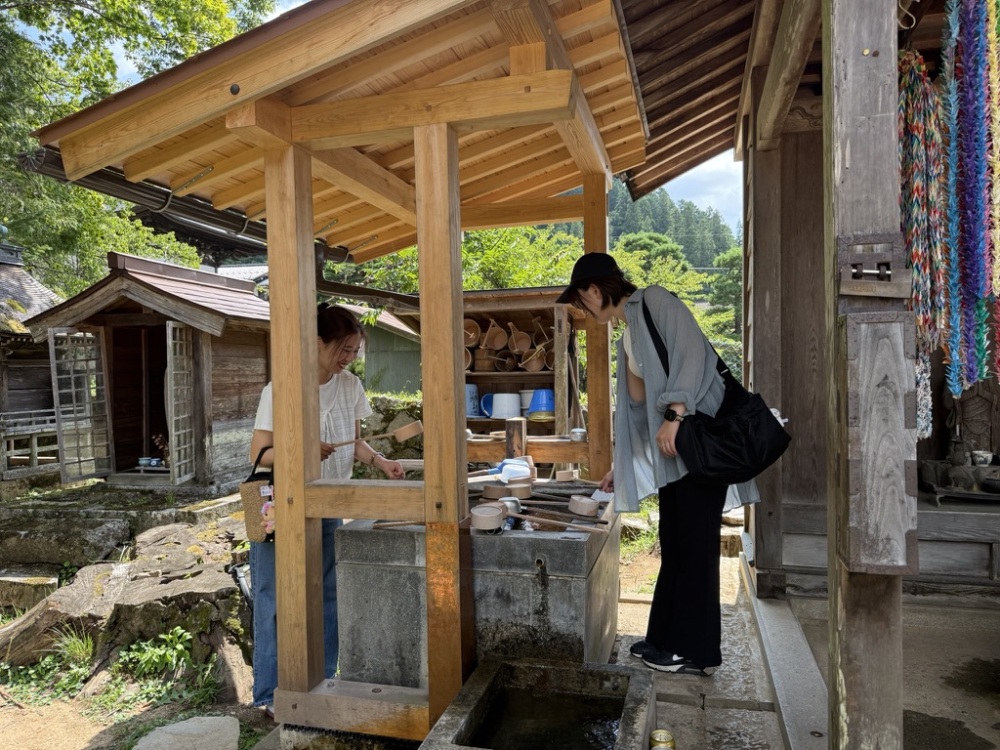 手水舎で水を汲み浄行菩薩様（洗い仏様）を洗います。