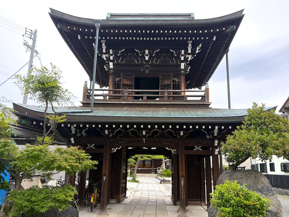 聞得寺の立派な鐘楼門。ふと横に目をやると　→